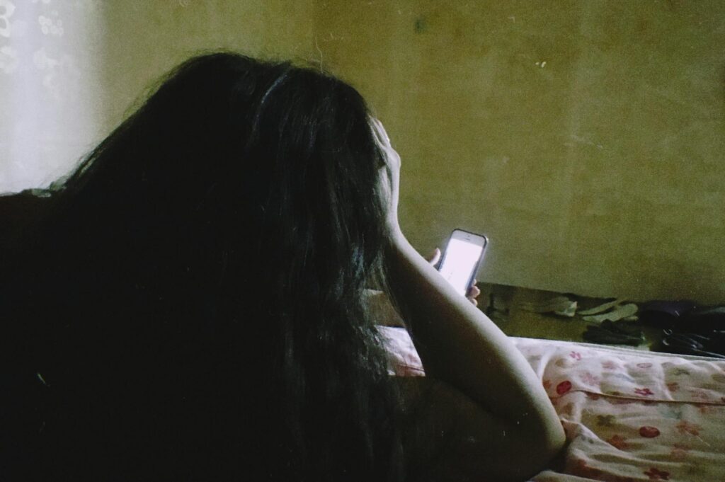 young woman using smartphone in dark room