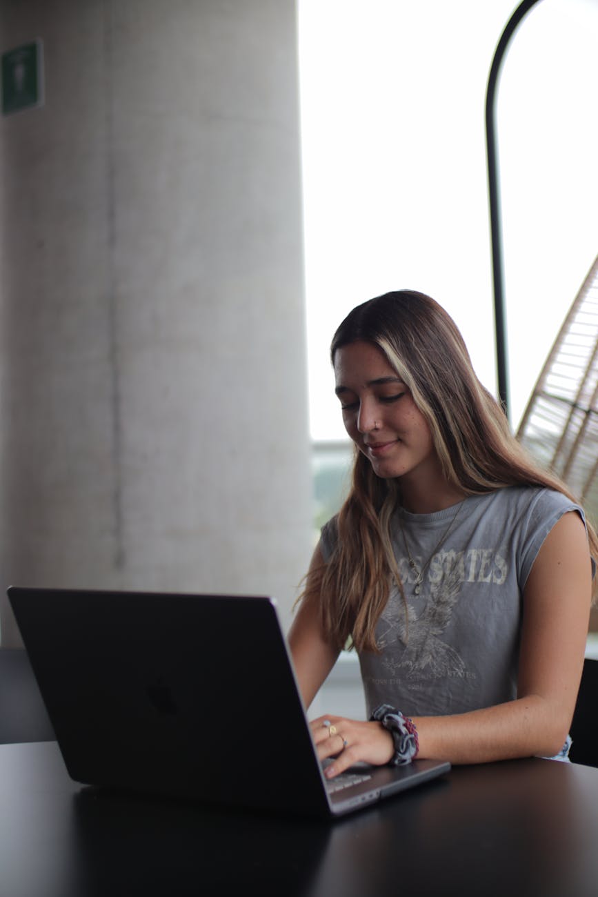 a woman sitting at a table with a laptop